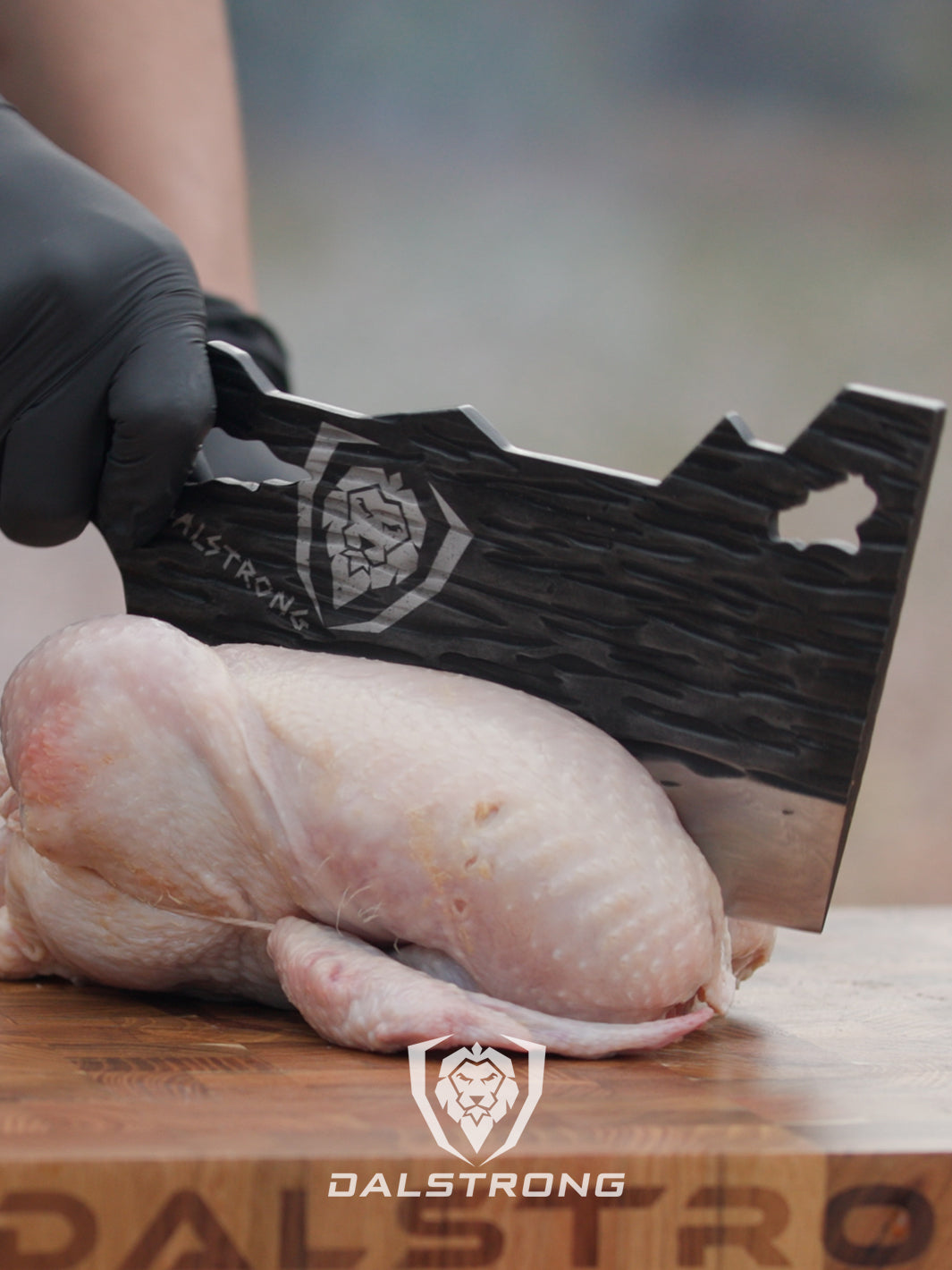 Dalstrong barbarian series obliterator cleaver knife and a whole chicken on a cutting board.