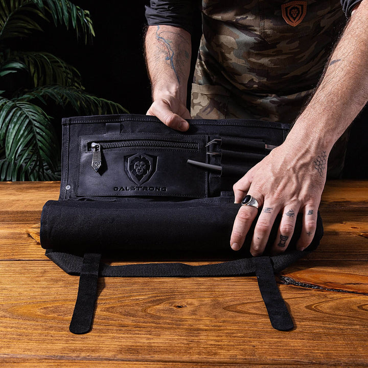 Dalstrong 12oz heavy-duty canvas and leather black nomad knife roll showcasing the dalstrong logo on it.