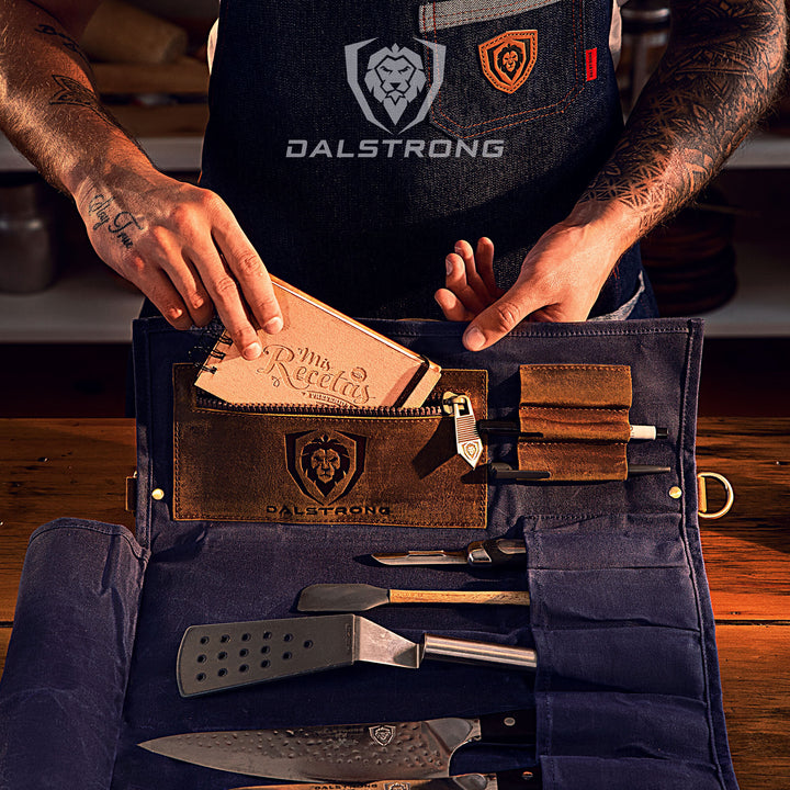 Dalstrong 12oz heavy-duty canvas and leather blue nomad knife roll with knives and kitchen utensils inside.
