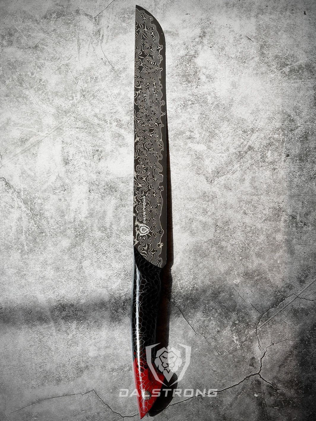 A man holding the Dalstrong scorpion series 11 inch slicing knife with red handle on a rough surface.