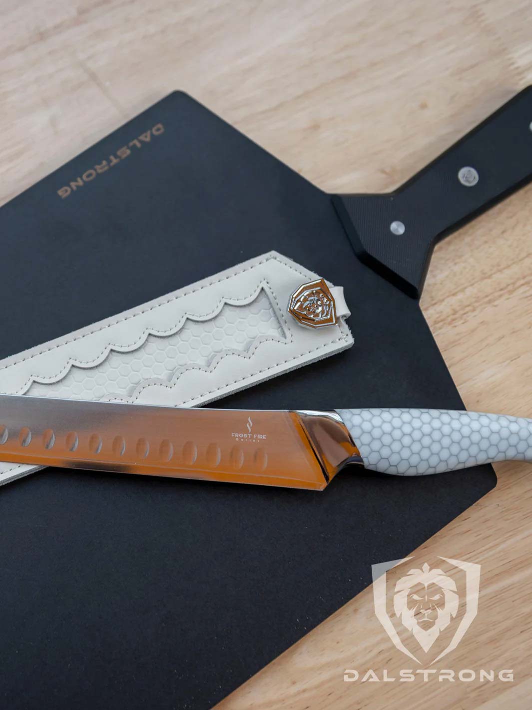 Dalstrong frost fire series 12 inch slicer knife with honeycomb handle and sheath on top of a cutting board.