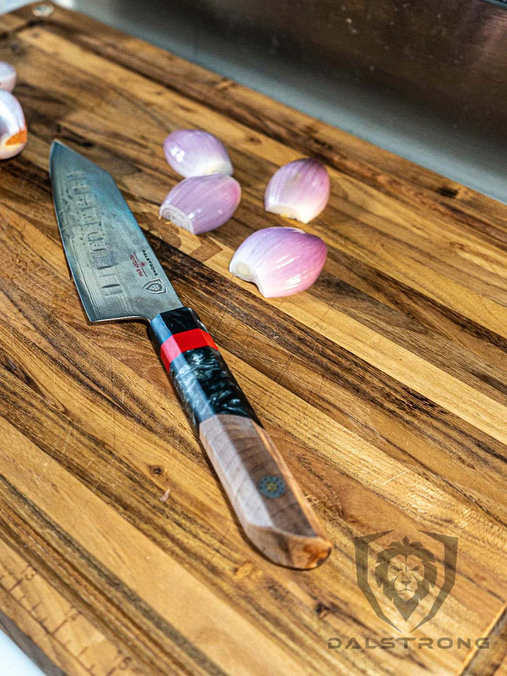 Dalstrong firestorm alpha series 7 inch santoku knife with wooden handle and slices of onions on a cutting board.