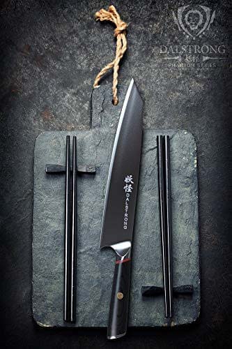 Dalstrong phantom series 9.5 inch chef knife in between two chopsticks on a cutting board.