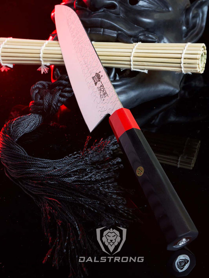 Dalstrong ronin series 7 inch santoku knife with black handle and a oni mask beside.