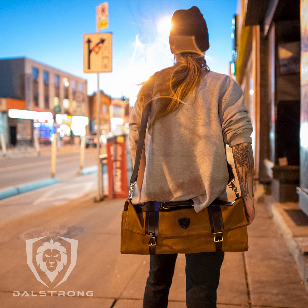 A man using the Dalstrong 12 oz heavy-duty canvas and leather nomad knife roll.