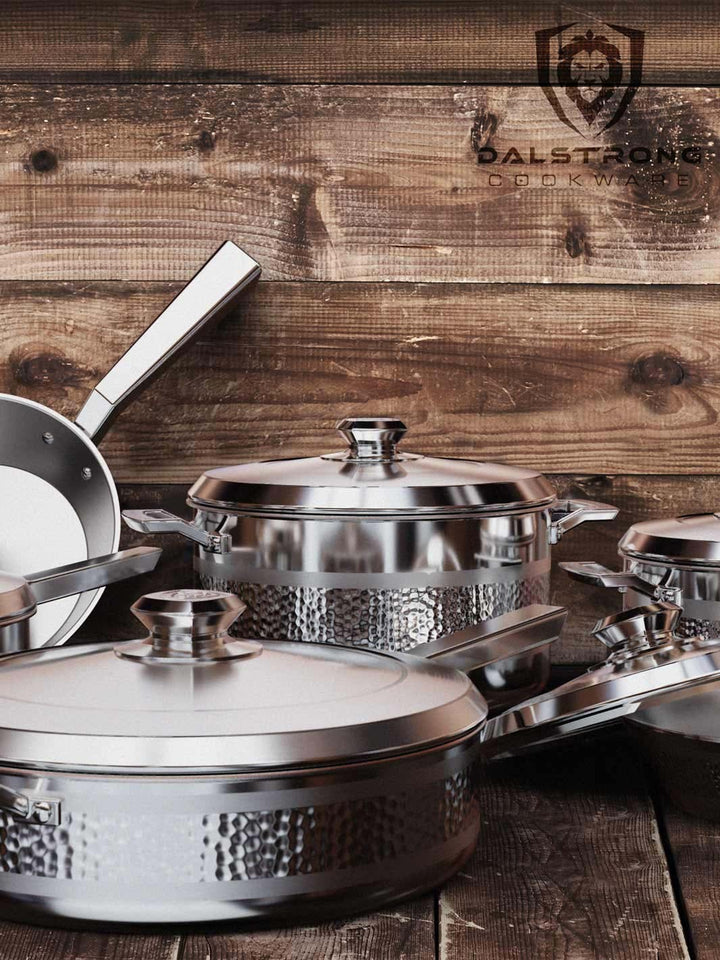 Dalstrong avalon series 12 piece cookware set silver on a wooden table.