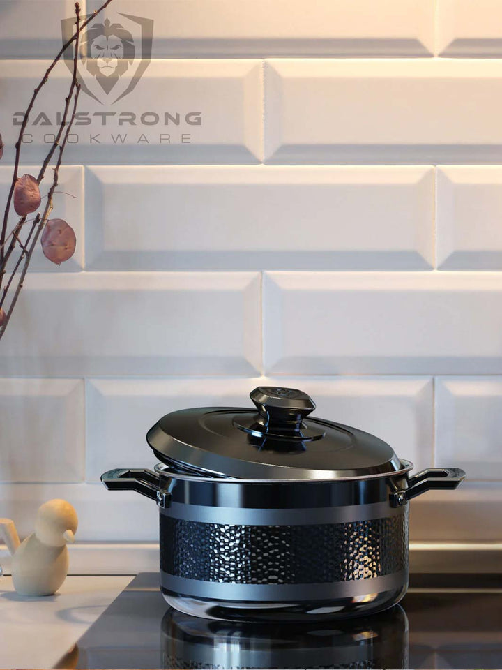Dalstrong avalon series 5 quart stock pot hammered finish black on a stove top.