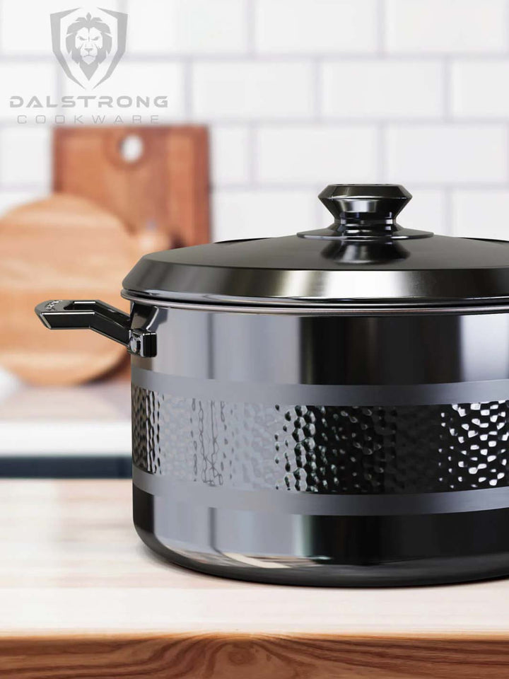 Dalstrong avalon series 8 quart stock pot hammered finish black on a wooden table.