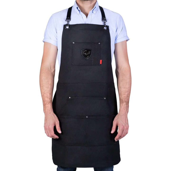 A man wearing the Dalstrong sous team apron heavy-duty waxed canvas chef's apron.