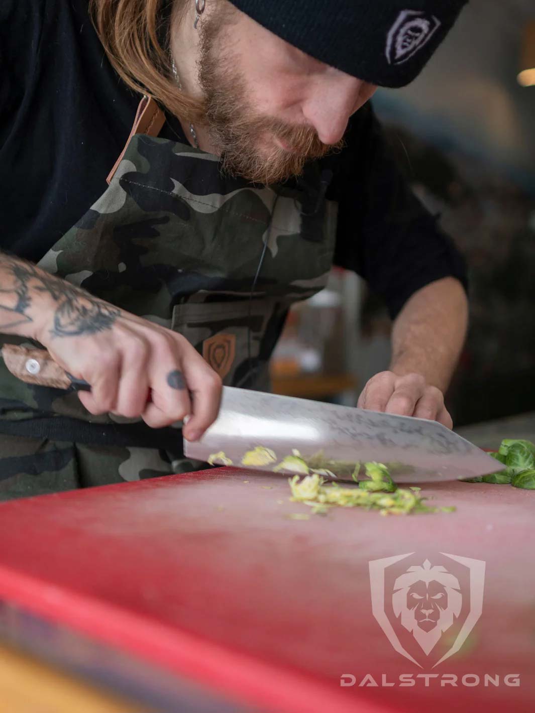 Dalstrong firestorm alpha series 9.5 inch chef knife with wooden handle slicing through a brussel sprout.
