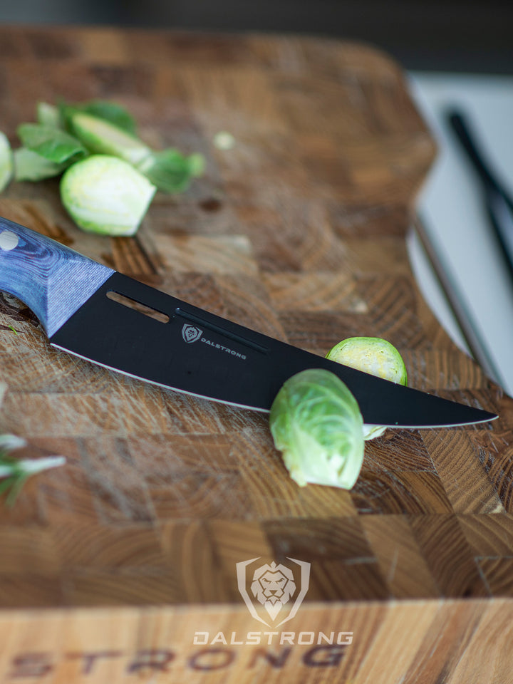 Dalstrong delta wolf series 6 inch curved fillet knife with brussel sprouts cut in half on a cutting board.