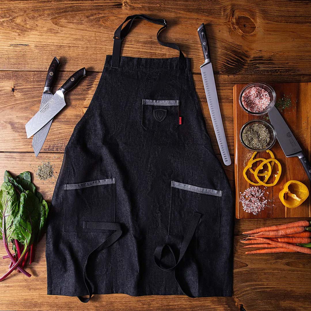 Dalstrong the night rider professional chef's kitchen apron with dalstrong knives beside it.