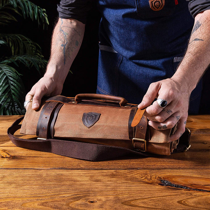 Dalstrong 12 oz heavy-duty canvas and leather nomad knife roll on a wooden table.