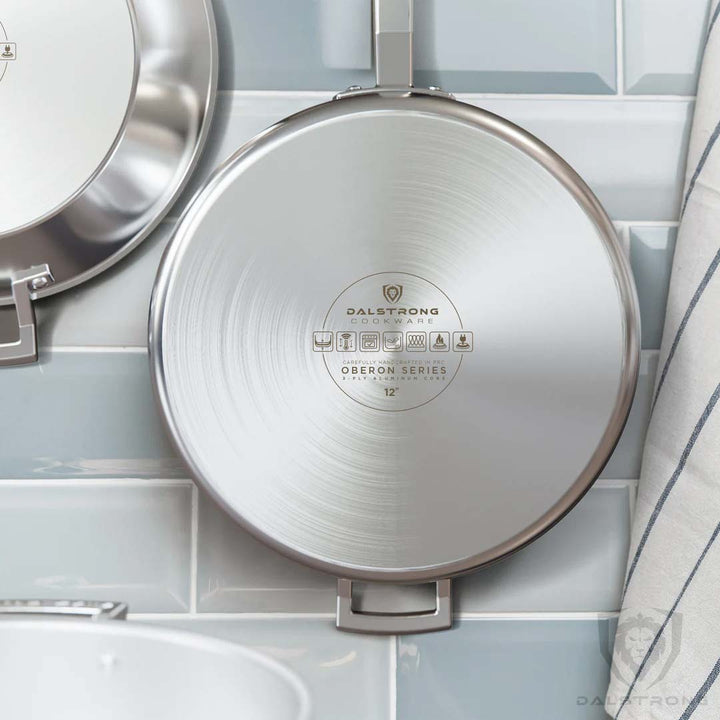 Dalstrong oberon series 12 inch silver saute frying pan hangin on a wall.