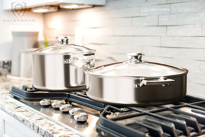 Dalstrong oberon series 6 piece cookware silver set on a kitchen stovetop.