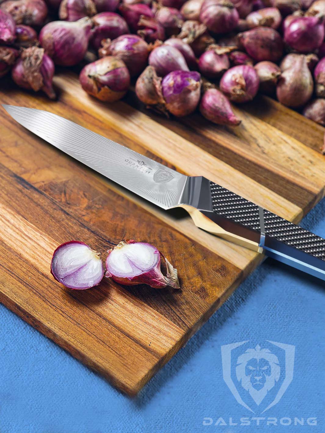 Dalstrong quantum 1 series 6 inch utility knife with dragon skin handle and onions ona a cutting board.