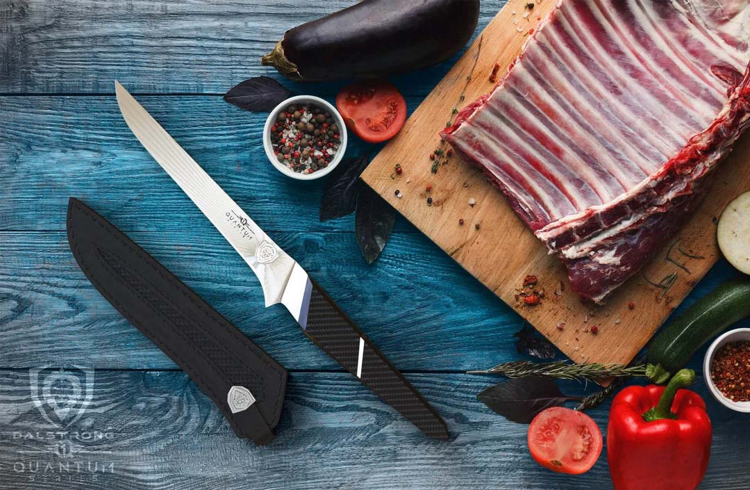 Dalstrong quantum 1 series 6 inch boning knife with dragon skin handle and a whole rack of ribs on a cutting board.