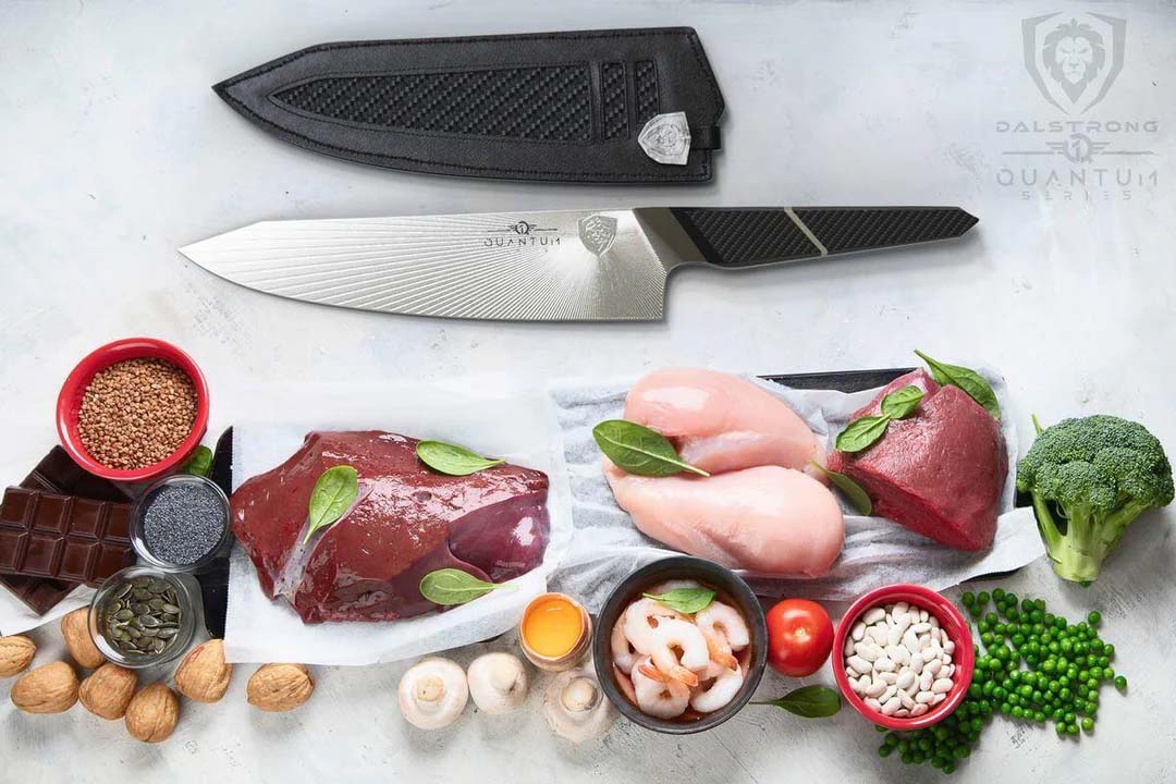Dalstrong quantum 1 series 8 inch chef knife with dragon skin handle and sheath beside two chicken breast and liver.