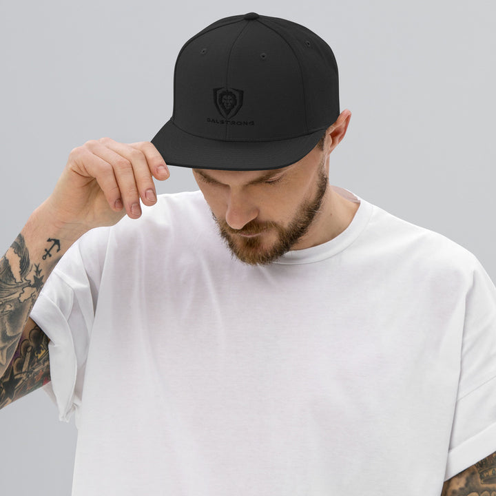 A man with white t-shirt wearing the Dalstrong classic snapback black hat.