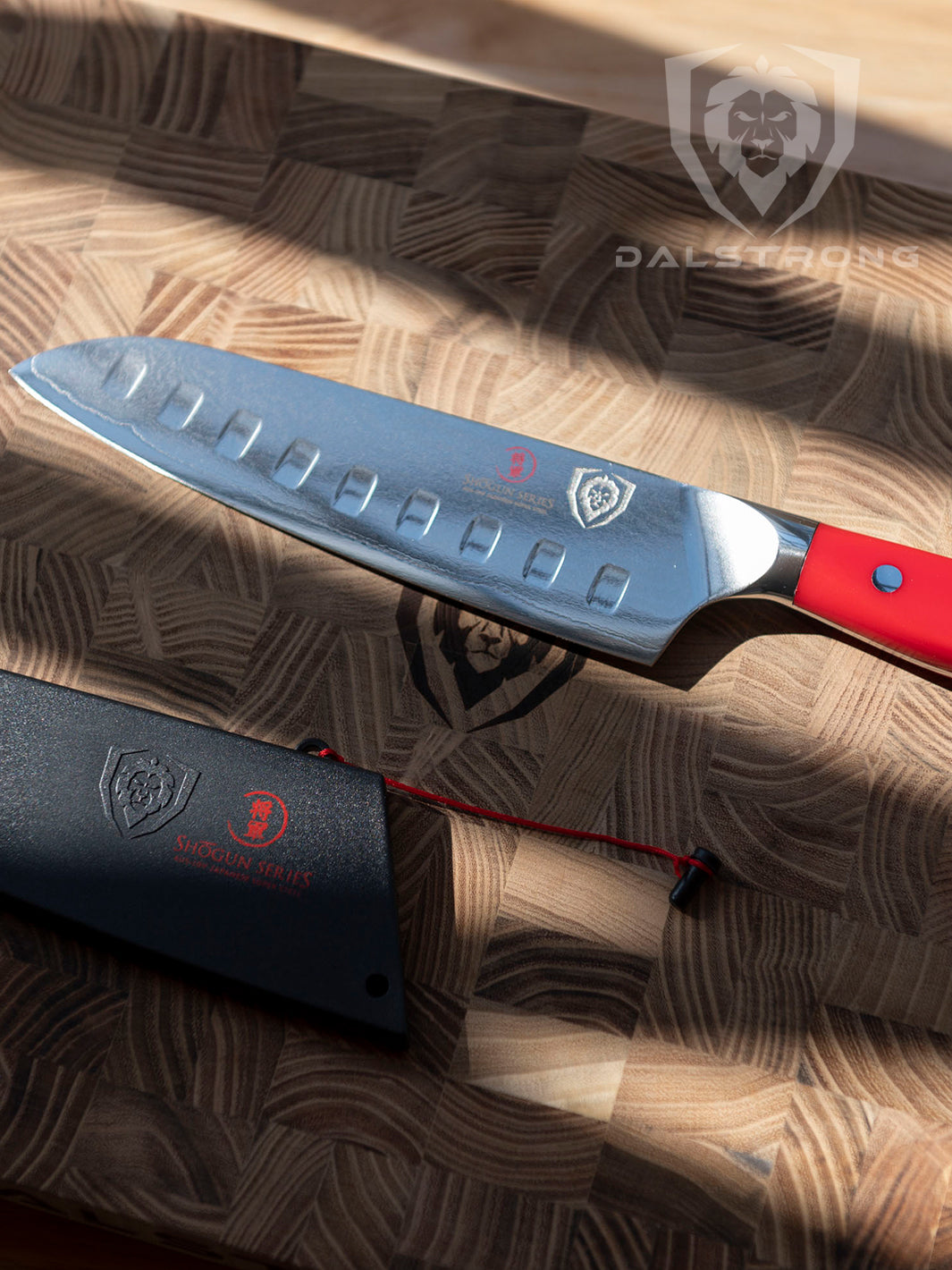 Dalstrong shogun series 7 inch santoku knife with crimson red handle and black sheath on a dalstrong wooden board.