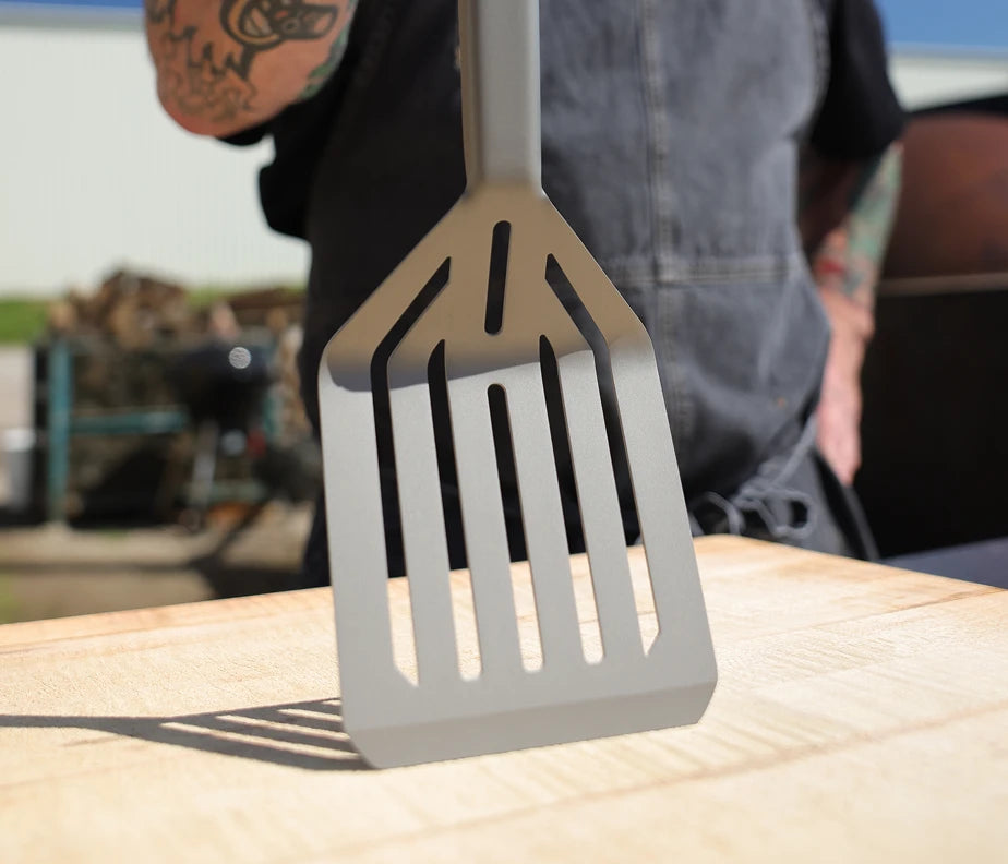 <h6>Heat and corrosion, handled.</h6><p>The Titanium Nitride coating boosts the steel’s resistance to both, keeping the spatula in working condition through years of direct-flame cooking.</p>