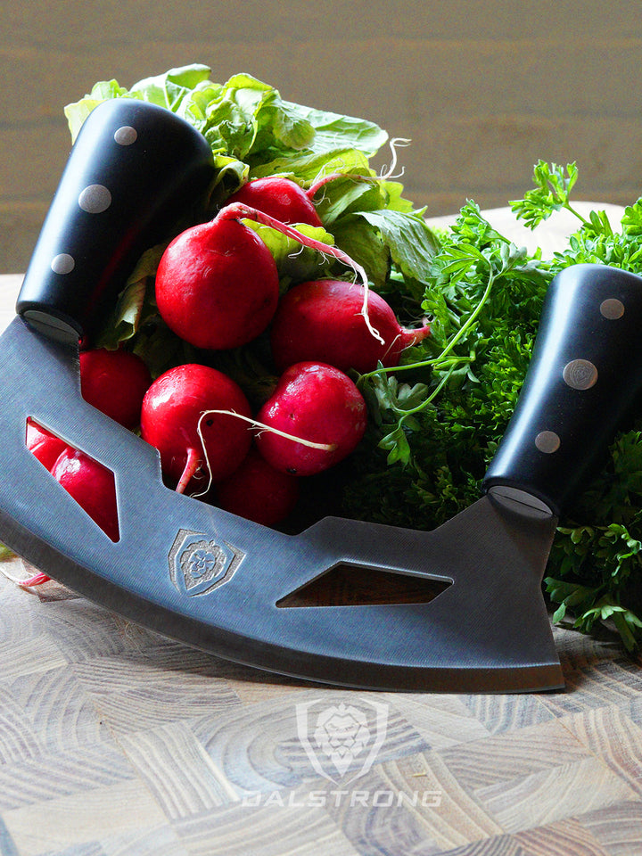 Dalstrong gladiator series 8.5 inch mezzaluna knife with black handle and parsley on a wooden cutting board.