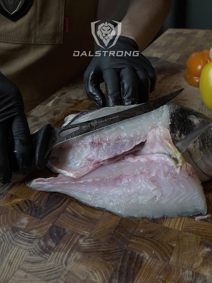 Dalstrong night shark series 7 inch fillet knife with water proof handle beside a fillet of fish.