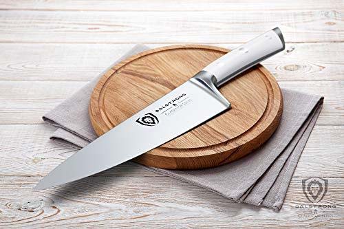 Dalstrong gladiator series 8 inch chef knife with white handle on top of a round wooden board.