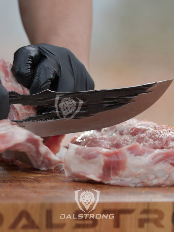 Dalstrong barbarian series 8 inch chef knife with wooden handle cutting through a meat.