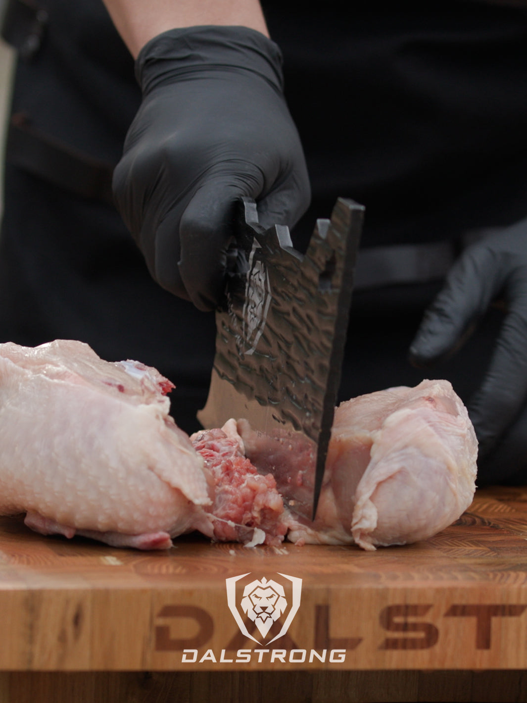 Dalstrong barbarian series obliterator cleaver knife with a chicken cut in half.