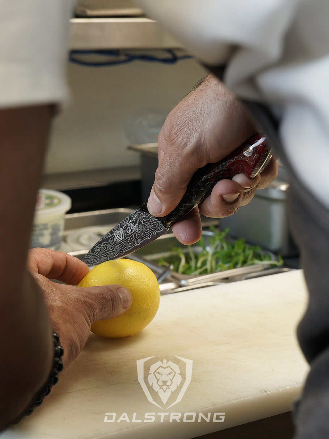 Dalstrong scorpion series 4 inch paring knife with red handle and a lemon on a cutting board.