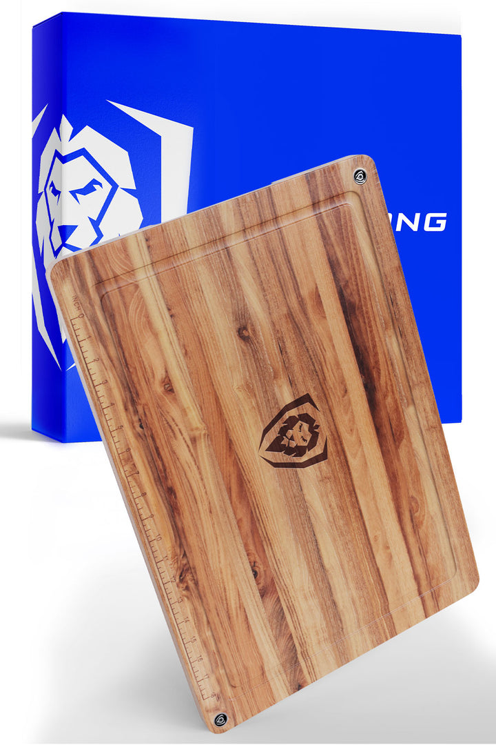 Dalstrong horizontal grain teak cutting board in front of it's premium packaging.