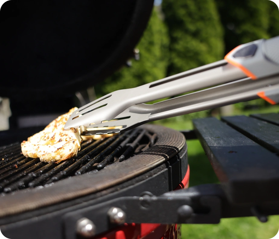 <h6><strong>No backing off the fire.</strong></h6><p>Reach into the flame, lean over the coals, work close to the grates. The tongs take it.</p><h6>Lightweight build, heavy duty toughness. </h6><p>Stainless steel heads, Titanium Nitride coated for heat and corrosion resistance. The gear you grab without thinking and work with for hours on end, if that’s what the job calls for.</p>