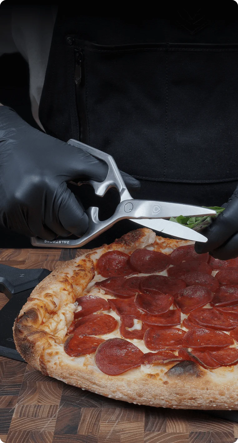 Vanquish kitchen shears snipping fresh herbs over pizza