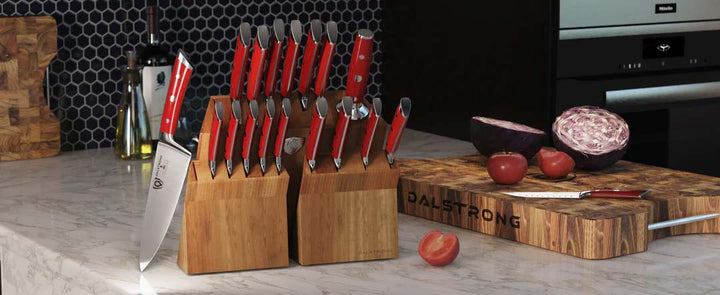 Dalstrong gladiator series 18 piece knife set with red handles and block on a kitchen table with the dalstrong wooden board.
