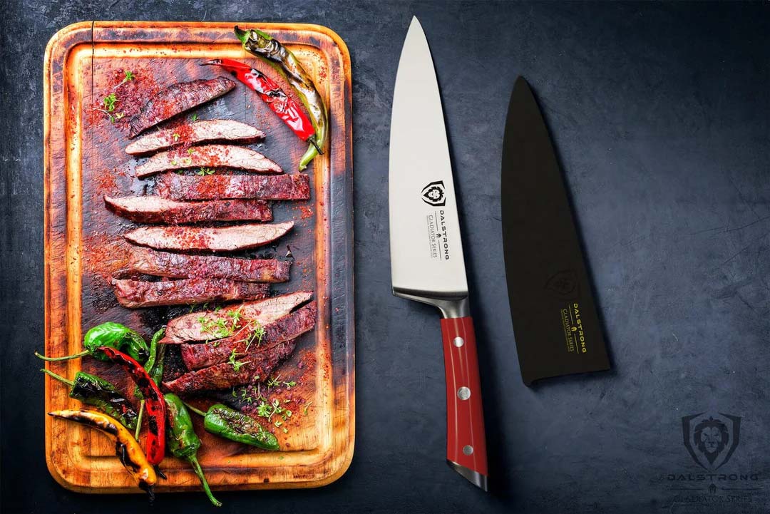 Dalstrong gladiator series 8 inch chef knife with red handle and slices of steak on a wooden board.