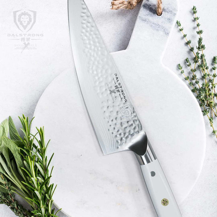 Dalstrong shogun series 8 inch chef knife with knife handle on top of a wooden white board.
