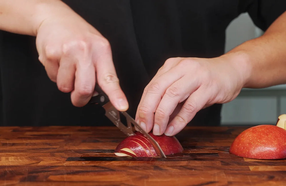 An Arro knife cutting clean, thin slices through an apple