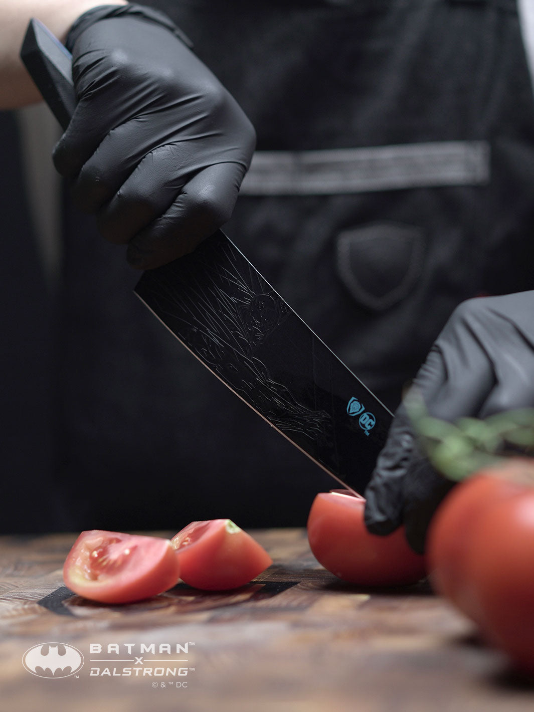 Dalstrong shadow black series 8 inch chef knife batman edition with cuts of tomatoes on a cutting board.