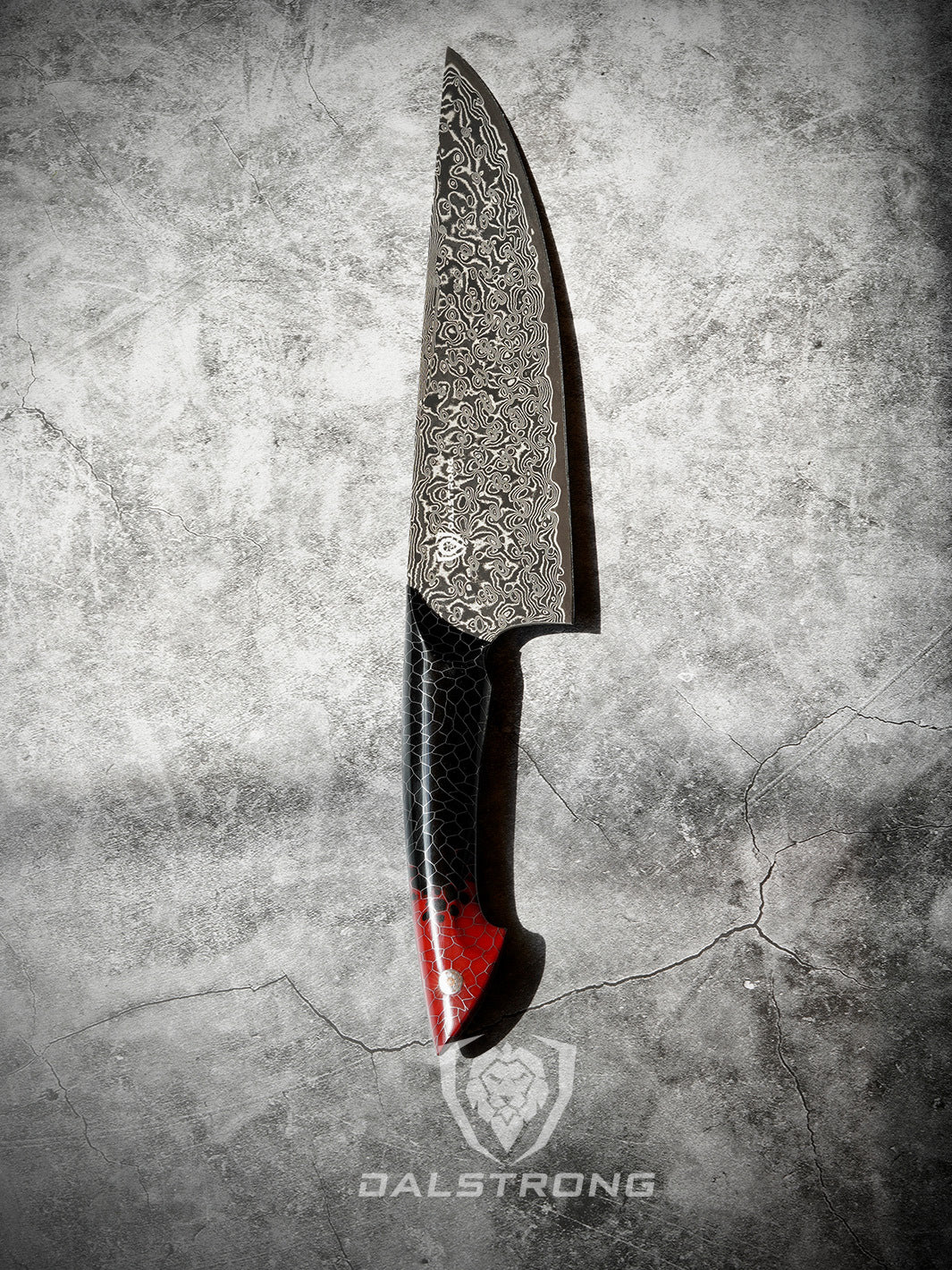 Dalstrong scorpion series 9.5 inch chef knife with red handle on a rough surface.