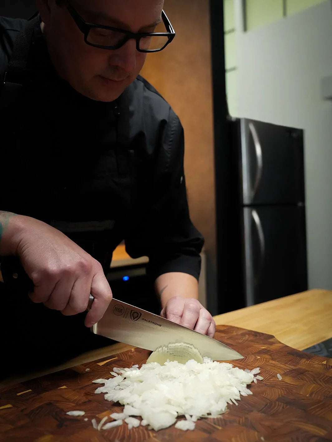 A cook chopping onions with the Gladiator 8-inch chef’s knife