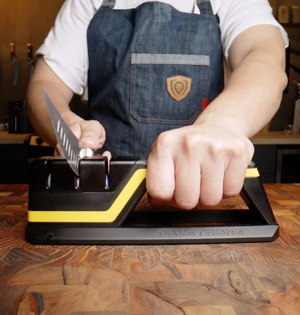 A cook holding Hornet securely while sharpening a knife on a kitchen worktop