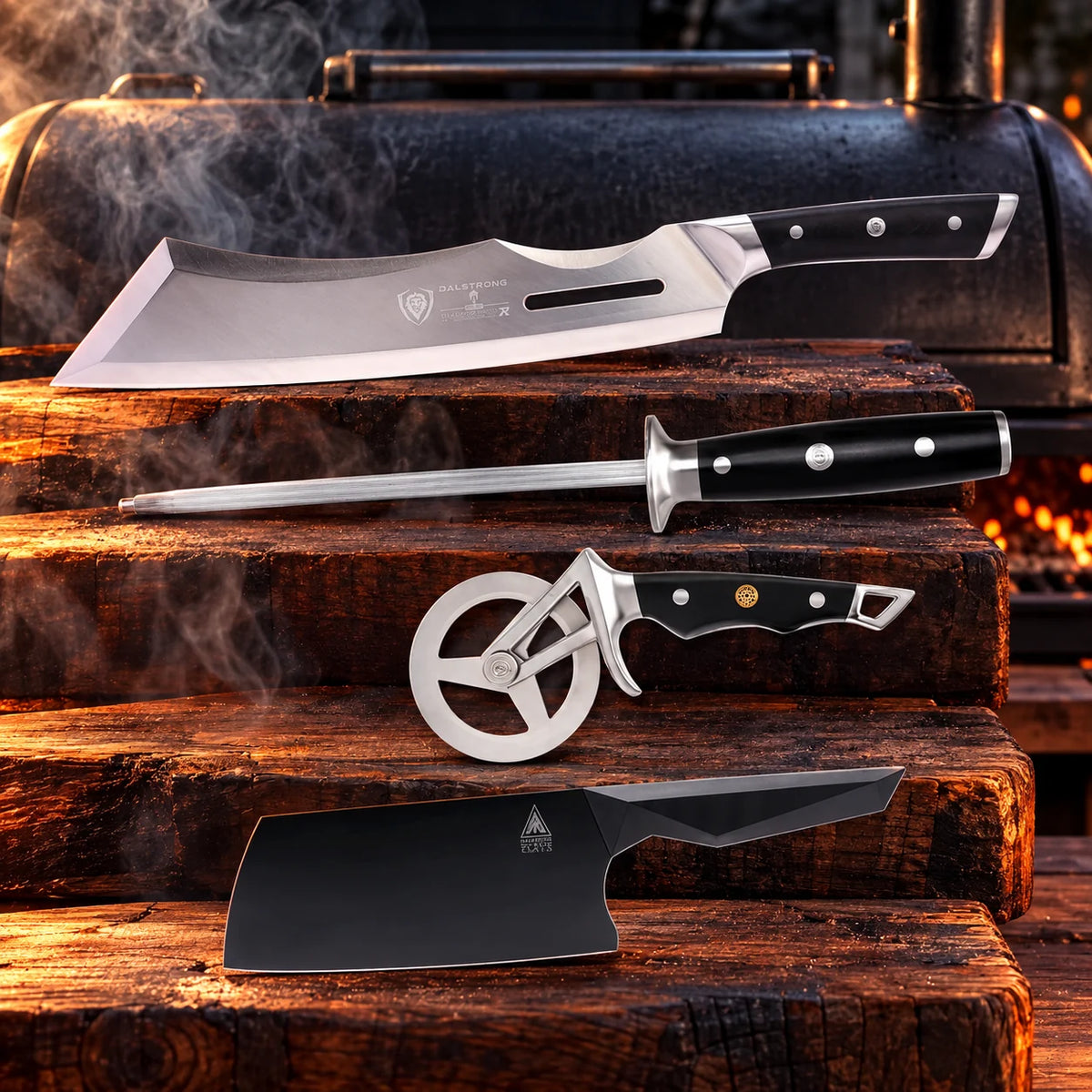 The Pit Boss bundle in a smoky BBQ setting with warm wood: Gladiator 14-inch Annihilator, Gladiator 10-inch honing steel, Orbit Razor pizza wheel, Shadow Black 7-inch cleaver (FREE)