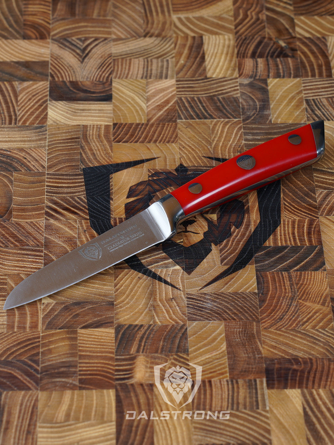 Dalstrong gladiator series 3.5 inch paring knife with red handle on a dalstrong wooden cutting board.