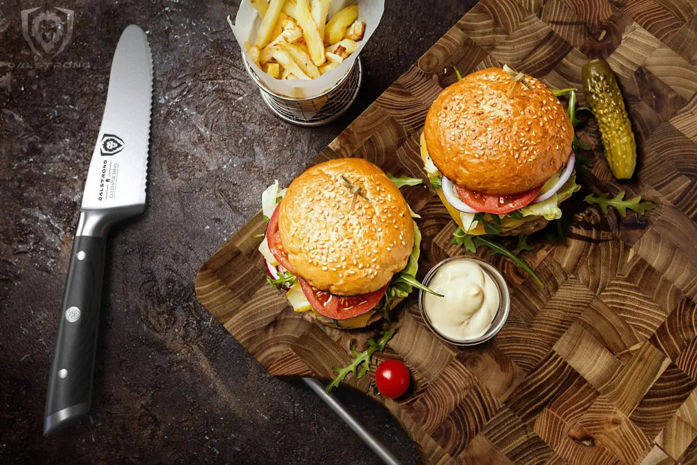 Burgers and a Dalstrong knife on a teak cutting board