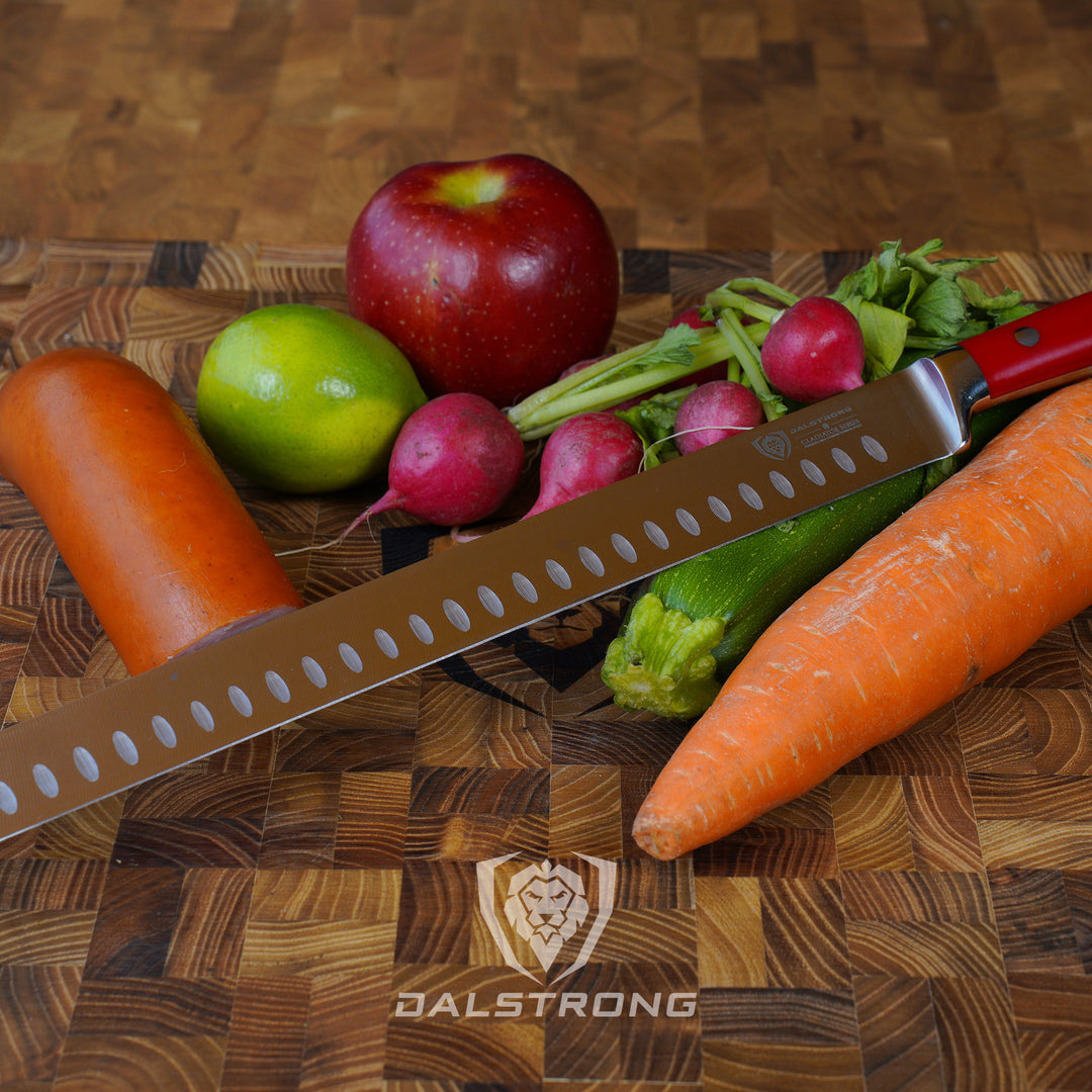 Dalstrong gladiator series 12 inch slicer knife with red handle and vegetables on a cutting board.