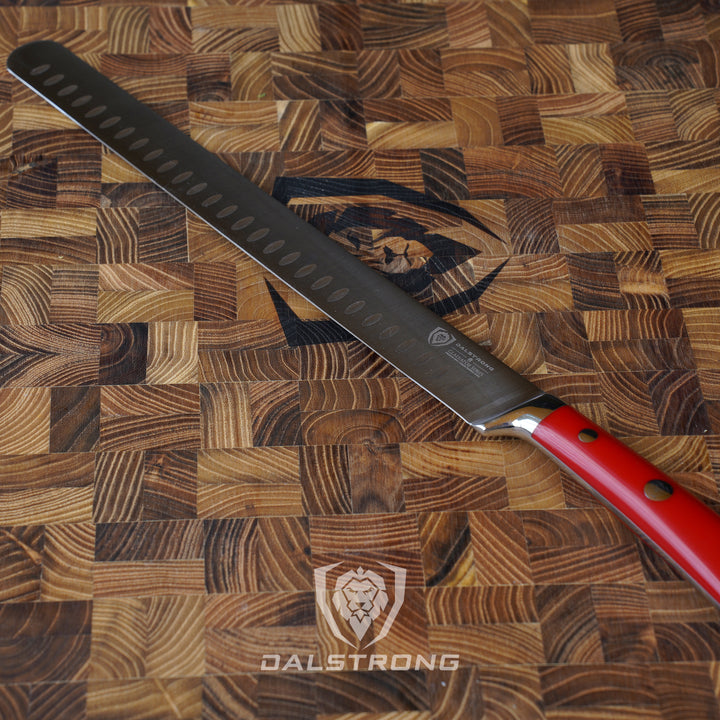 Dalstrong gladiator series 12 inch slicer knife with red handle on a dalstrong cutting board.