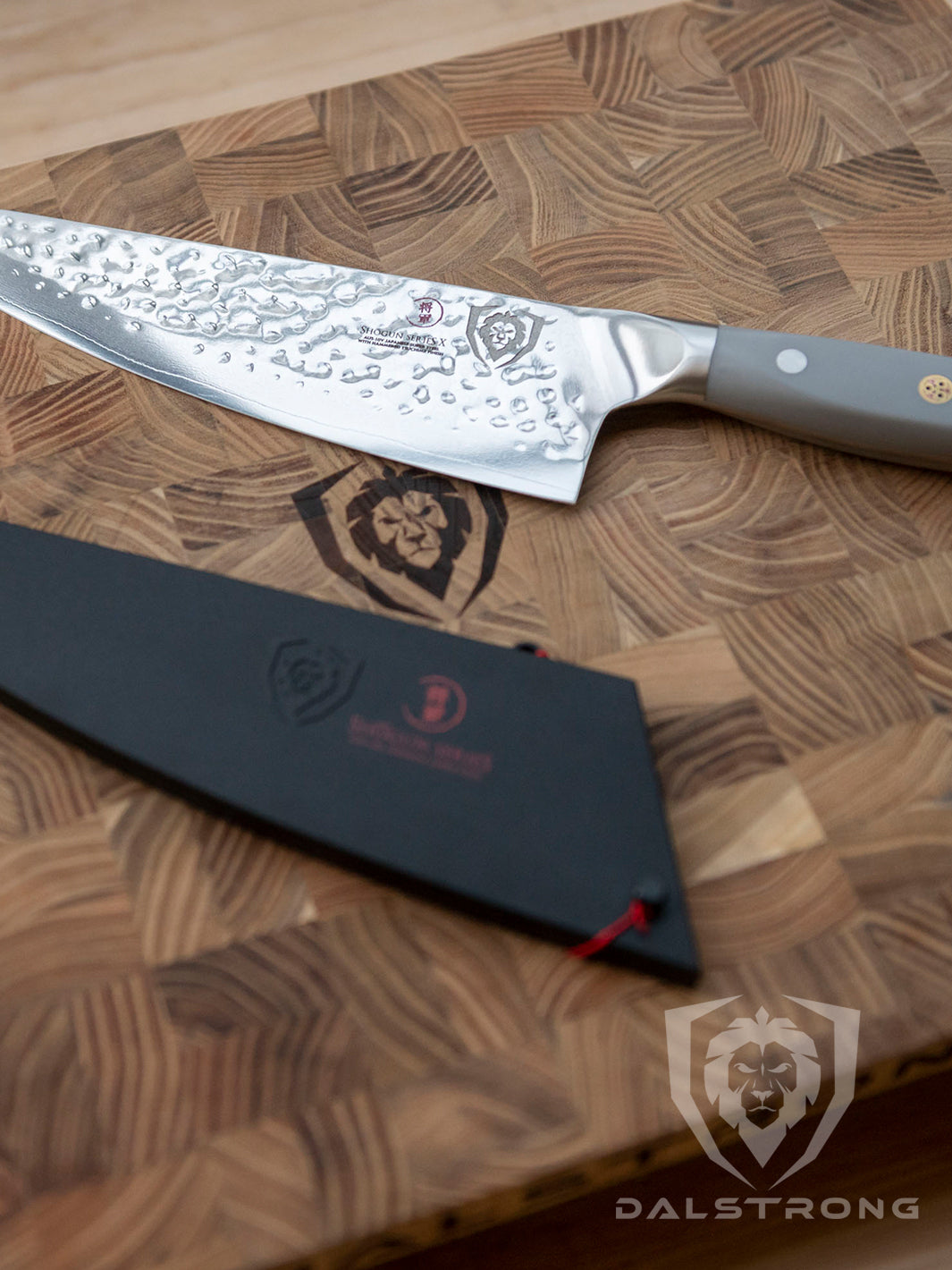 Dalstrong shogun series 8 inch chef knife with gray matte handle and sheath on top of a Dalstrong wooden board.