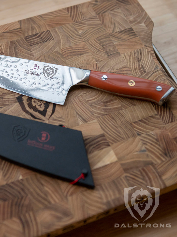 Dalstrong shogun series 8 inch chef knife with flame orange handle and sheath on top of a Dalstrong wooden board.