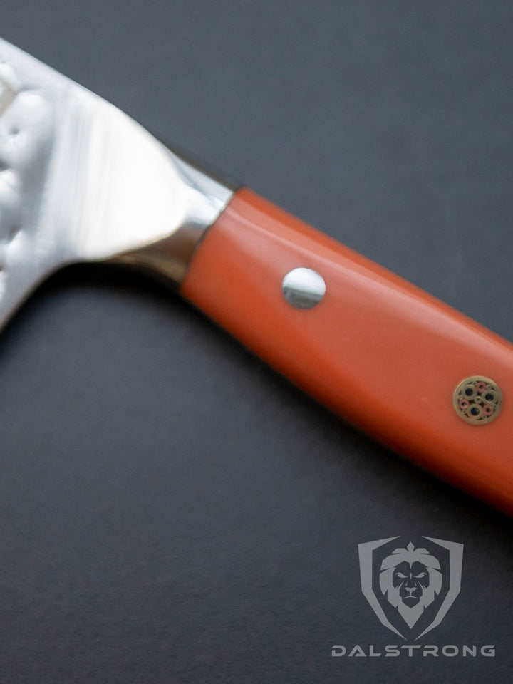 Dalstrong shogun series 8 inch chef knife with flame orange handle on a solid surface.
